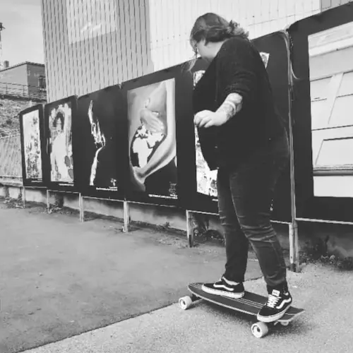 Photo de moi de dos, sur un skateboard, en noir et blanc